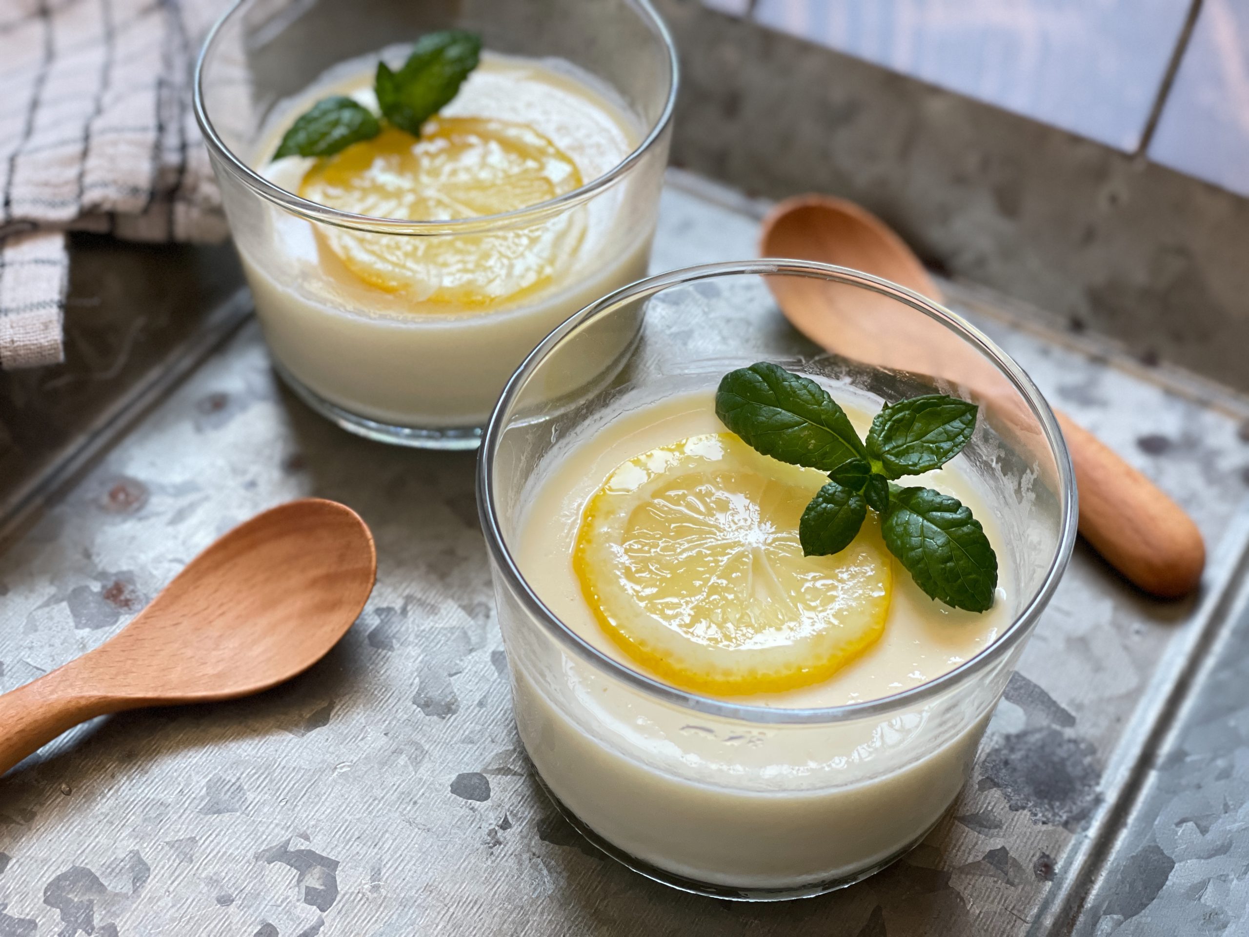 器に盛られたとろとろのレモンポセット。レモンの皮がトッピングされた爽やかな夏スイーツ。