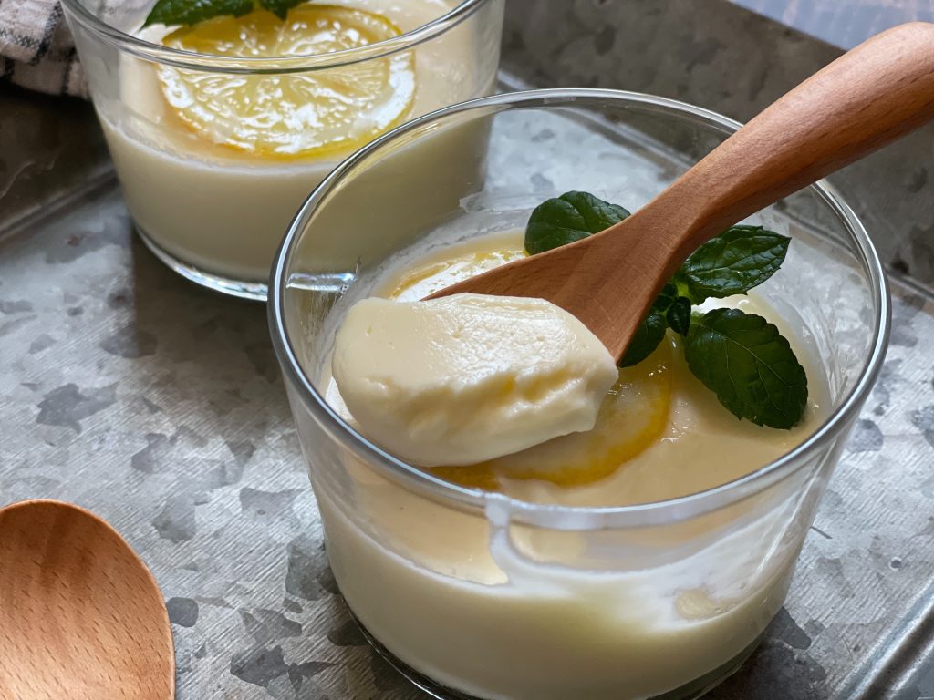 器に盛られたとろとろのレモンポセット。レモンの皮がトッピングされた爽やかなスイーツ。