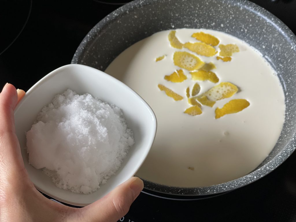 小鍋で生クリームとレモンの皮、砂糖を煮詰めている様子。
