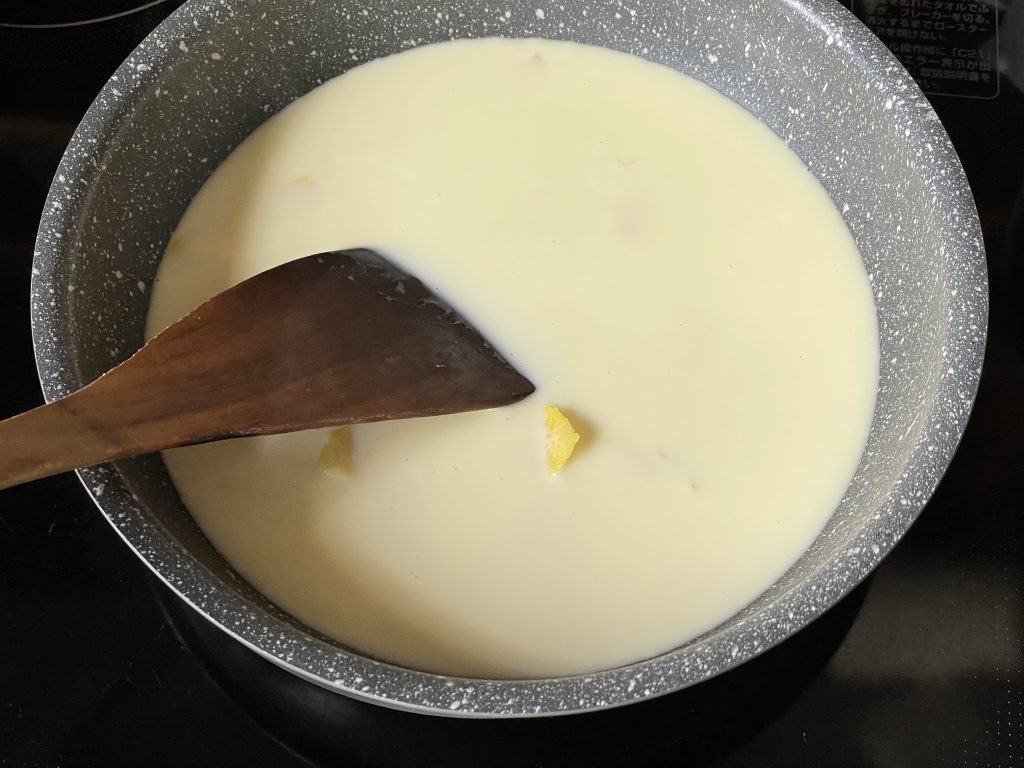 小鍋で生クリームとレモンの皮、砂糖を煮詰めている様子。