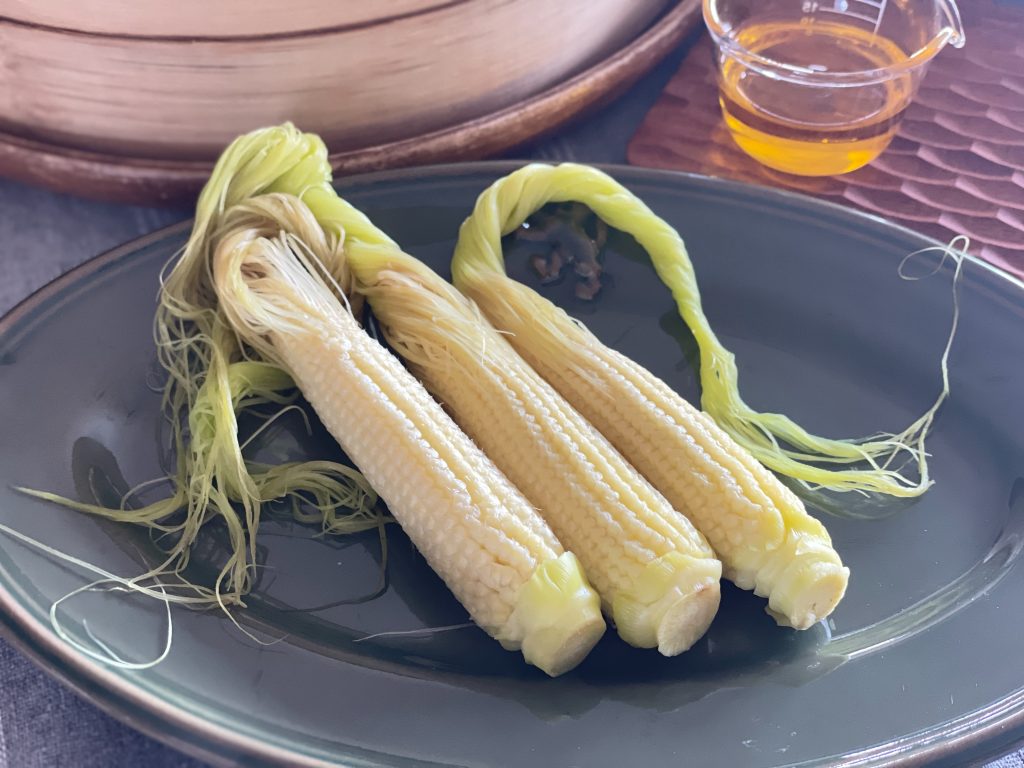 せいろに並べてふっくらと蒸し上がった、皮付きのみずみずしいヤングコーン。
